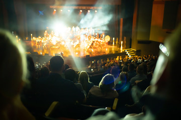 Lights on stage during concert in hall filled with spectators