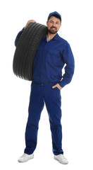 Full length portrait of professional auto mechanic with tire on white background