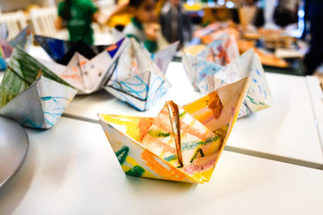 Homemade paper boats decorated with colors for children a day of crafts.