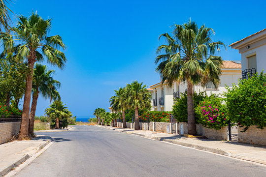 Cyprus. Protaras. The streets of Protaras. Walking the streets. Tourist resorts of Cyprus. Palm trees grow along the edges of the road. Roads of Cyprus on a sunny day. Mediterranean resorts.