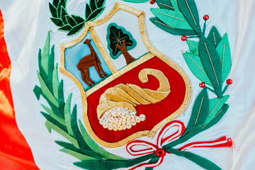 Embroidered Peru shield detail on the national flag.