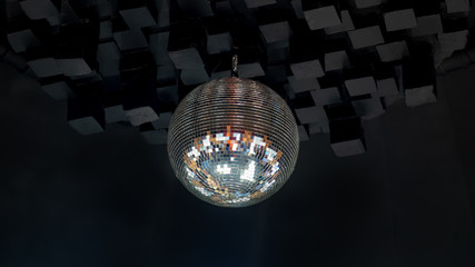 Dico ball on black cube style ceeling in nightclub with striped white and black walls lit by spotlight, party and nightlife entertainment industry