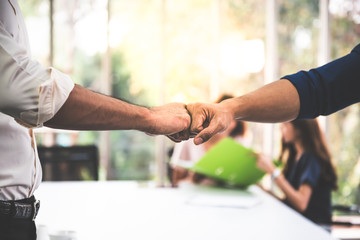 Close up images, the hand of Business men Fist bump with blurred of business women meeting at workplace, concept to business teamwork for success