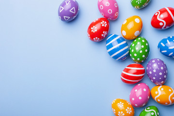 Flat lay composition with Easter eggs on color background. Frame made of decorated eggs. Top view with place for text