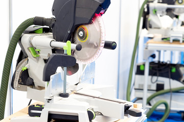 Stationary circular saw. Circular saw against the background of a carpentry workshop. Concept - sale of equipment for wood processing. New circular saw close up. Equipment for the carpentry workshop