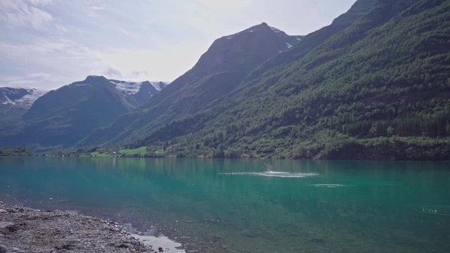 Stone skipping into the beautiful green lake oldevatnet in norway