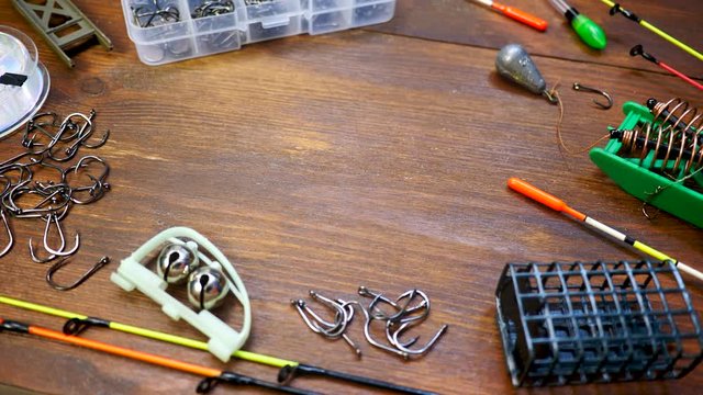 Fishing rod and tackle on wooden brown table background. Item of angling equipment: fishing float (or bobber in US), fishing line cord and hooks, weight fishing sinker or knoch. Copy space for text