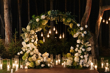 Evening wedding ceremony with garlands of lamps
