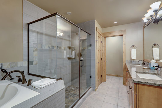 Natural tones large luxury condo or home bathroom interior.