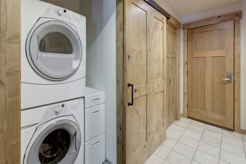 Nice laundry room washer and dryer stack on each other in condo hallway.