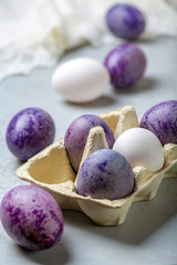 Stylish blue and purple Easter eggs in a paper tray.