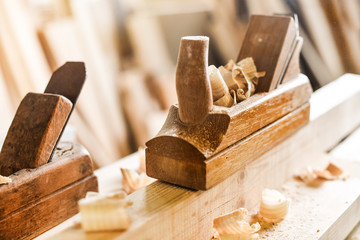 The carpenters using old spokeshave or plane to decorate the woodboard.