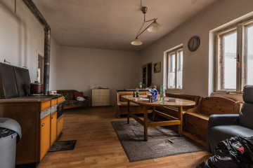 wohnzimmer mit tisch und ofen in einem alten haus