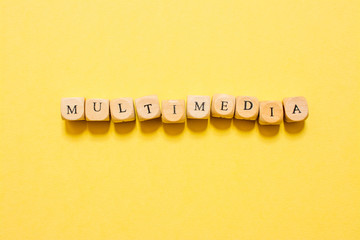 the word Multimedia, text made with dice on yellow background