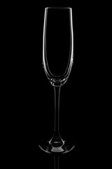 Empty champagne glass on a black background, elegantly illuminated on the sides. Concept, mysterious club life. Magazine and commercial photo with place for text or design, festival and holiday food
