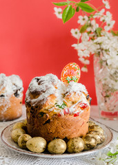Easter cake, quail colored eggs and a sprig of blooming cherry on the rustic white wooden background. Easter concept