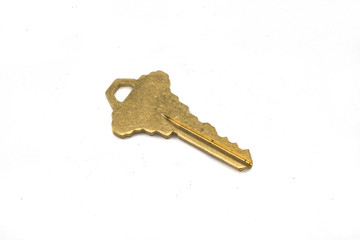 A gold door key, close up, isolated on a clean, white background.  Shot in macro.