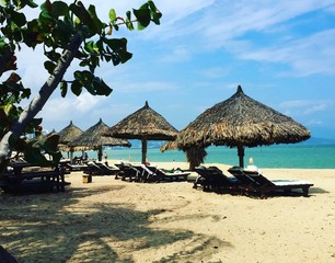 Fototapeta na wymiar tropical beach with chairs and umbrellas