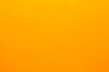 Orange background made of real colored paper, illuminated by a soft light from above.