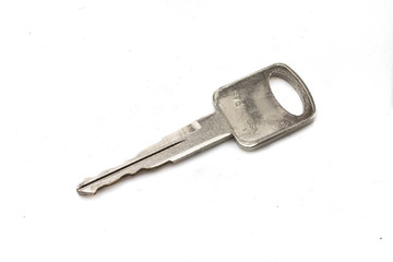 A shiny car key, close up, isolated on a clean, white background.  Shot in macro.