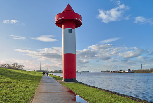 small lighthouse at Ritzenb&uuml;tteler Sand, municipality Lemwerder (district Wesermarsch, Germany) next to the river Weser on a sunny spring day with vivid blue sky and clouds