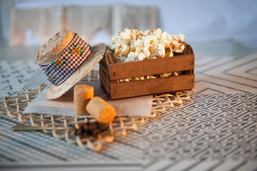 Selective focus. Straw hat, mini, candy, defocused. Popcorn, traditional in Brazilian June party. Caipira party. Light background. Seen up close. Horizontal. Space for your text.