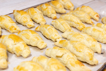 Just baked croissants on pan on white baking paper background