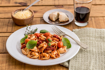 meat capelletis with three tomato sauce on a wooden table
