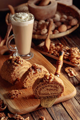 Walnut cake and coffee latte with cream on a wooden table.