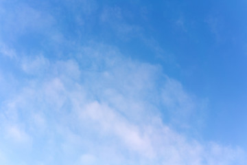 White cumulus clouds against the background against blue on a blue background.