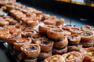 Selective focus of a tray full of round, fruity soft pastry goods arranged for breakfast at a delicatessen tray