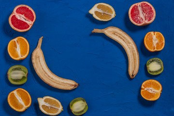 Juicy ripe fruits on a wooden blue background. Flat lay, top view. Pop art design, creative summer concept. Fruits in a minimalist style.Copy space