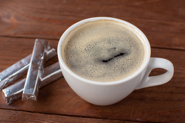 Espresso coffee on a wooden background with mini chocolates still Life . Selective focus.