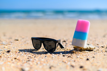 Ice cream with sunglasses on the beach with copying area