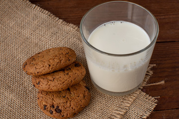 Homemade cow's milk with cookies on a wooden background. Rustic style. Still-life.