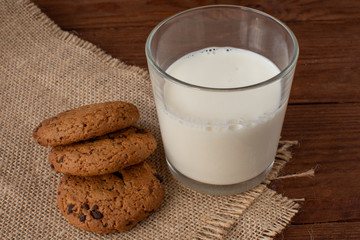 Homemade cow's milk with cookies on a wooden background. Rustic style. Still-life.