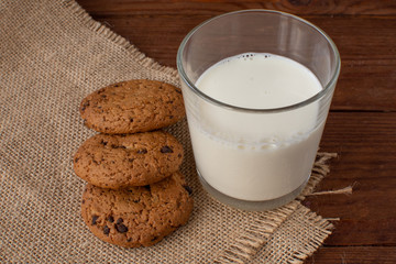 Homemade cow's milk with cookies on a wooden background. Rustic style. Still-life.