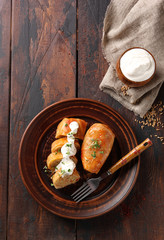 The concept of Eastern European cuisine. Stuffed cabbage with meat, rice and sour cream on a brown plate on a dark wooden background. Rustic. Background image, copy space