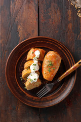 The concept of Eastern European cuisine. Stuffed cabbage with meat, rice and sour cream on a brown plate on a dark wooden background. Rustic. Background image, copy space