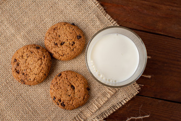 Homemade cow's milk with cookies on a wooden background. Rustic style. Still-life.