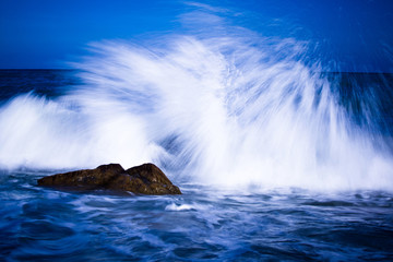 Inspirational mesmerizing seascape of stormy waves wishing among the stones in the evening. Concept of elements and nature of beauty. Copyspace