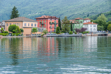 Fototapeta na wymiar Lakefront of Porto Ceresio with flowers and colored houses