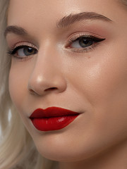 Closeup portrait of a woman with developing straight hair. Sweet tender young girl blonde. Natural lipstick, transparent clean skin. Skin care natural cosmetics in the spa salon or cosmetology.