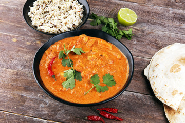 Chicken tikka masala spicy curry meat food in pot with rice and naan bread. indian food