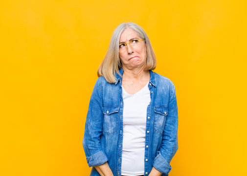 senior or middle age pretty woman looking goofy and funny with a silly cross-eyed expression, joking and fooling around