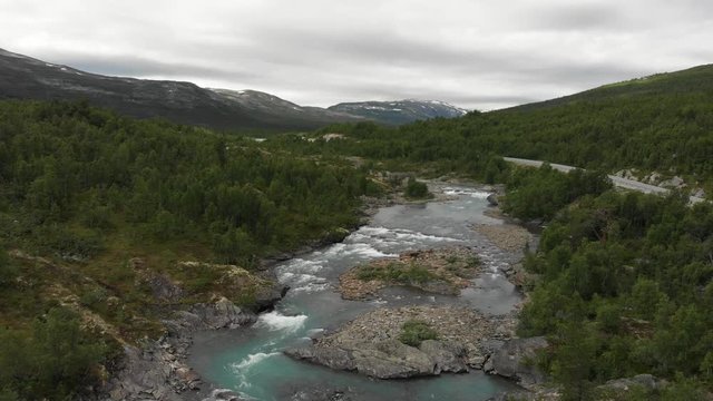 Beautiful wild river called Otta in Norway.
Filmed with drone, fly away.
A road and car in the background.