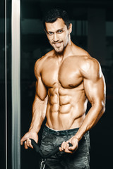 Fototapeta premium Bodybuilder strong man pumping up biceps muscles