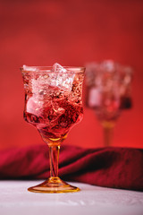 Soft focus photo of cocktail with gin and pomegranate bitter on red background