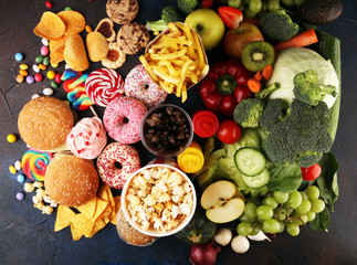 healthy or unhealthy food. Concept photo of healthy and unhealthy food. Fruits and vegetables vs donuts,sweets and burgers