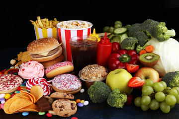 healthy or unhealthy food. Concept photo of healthy and unhealthy food. Fruits and vegetables vs donuts,sweets and burgers